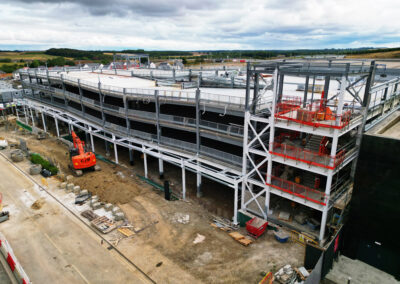 Striking drone construction photo of a multi storey car park with overcast backdrop.